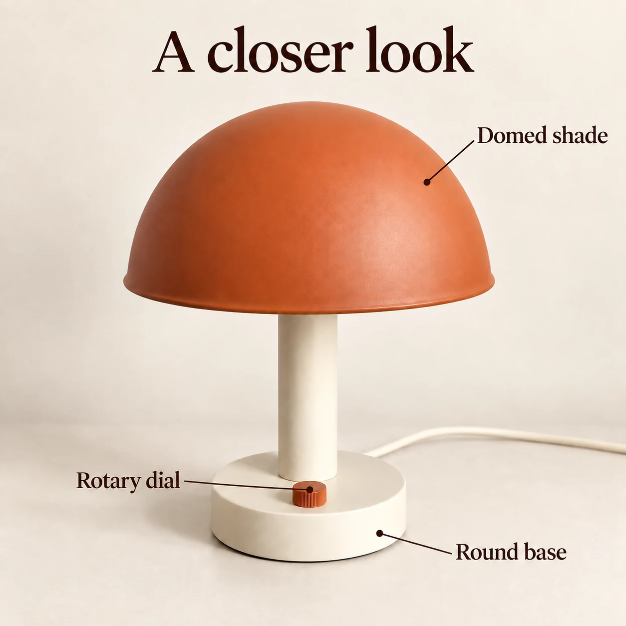 Desk lamp feature image with callouts for the domed shade, rotary dial, and round base.